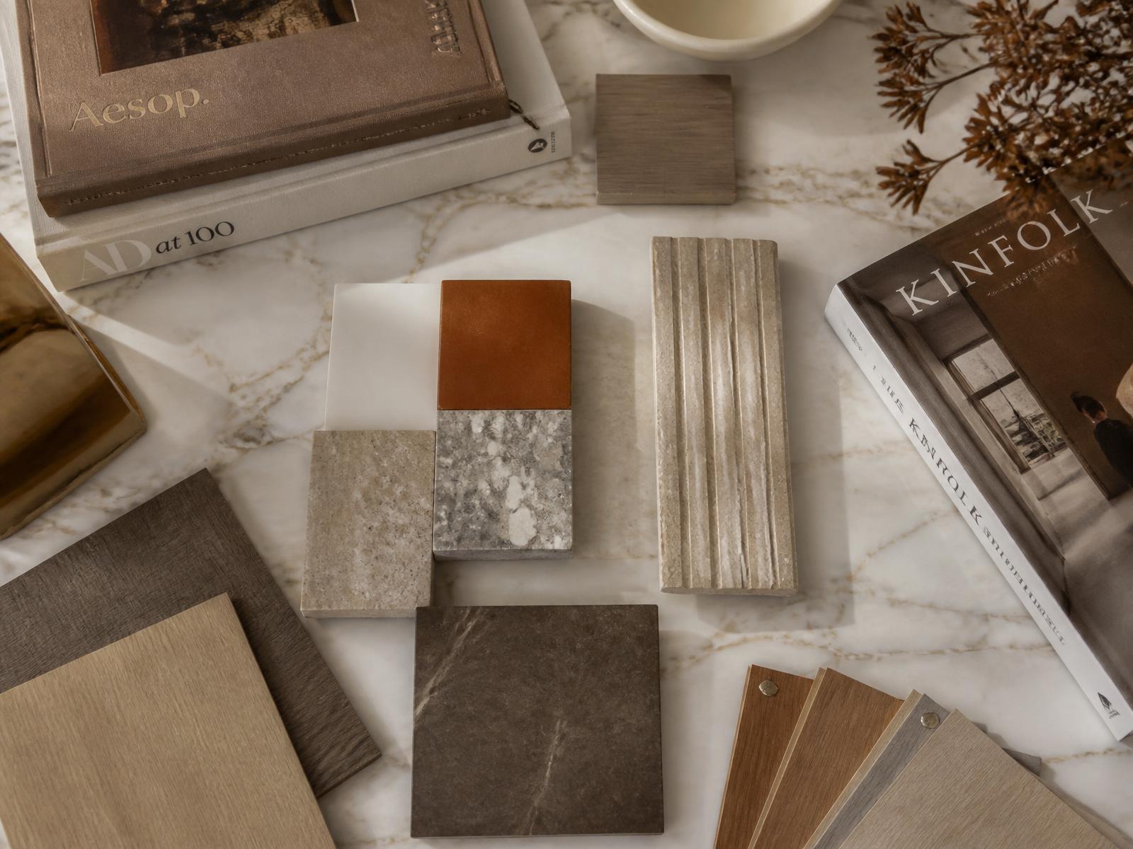 Design books and material samples arranged on a marble table